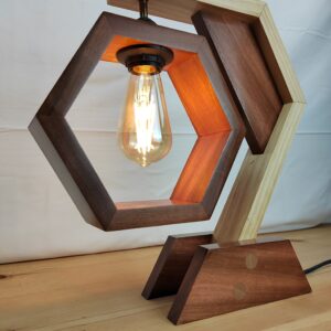 Lámpada artesanal de madeira con estrutura hexagonal, brazo bicolor e bombilla vintage Edison suspendida no centro