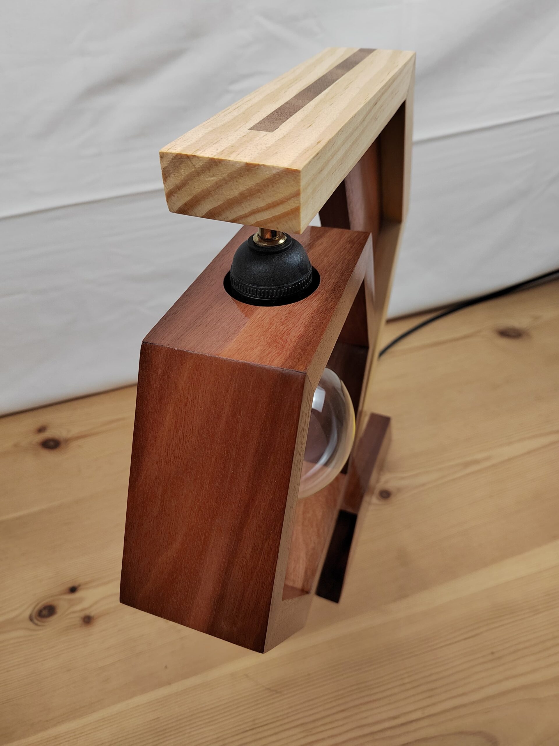 Lámpada artesanal de madeira con estrutura hexagonal, brazo bicolor e bombilla vintage Edison suspendida no centro