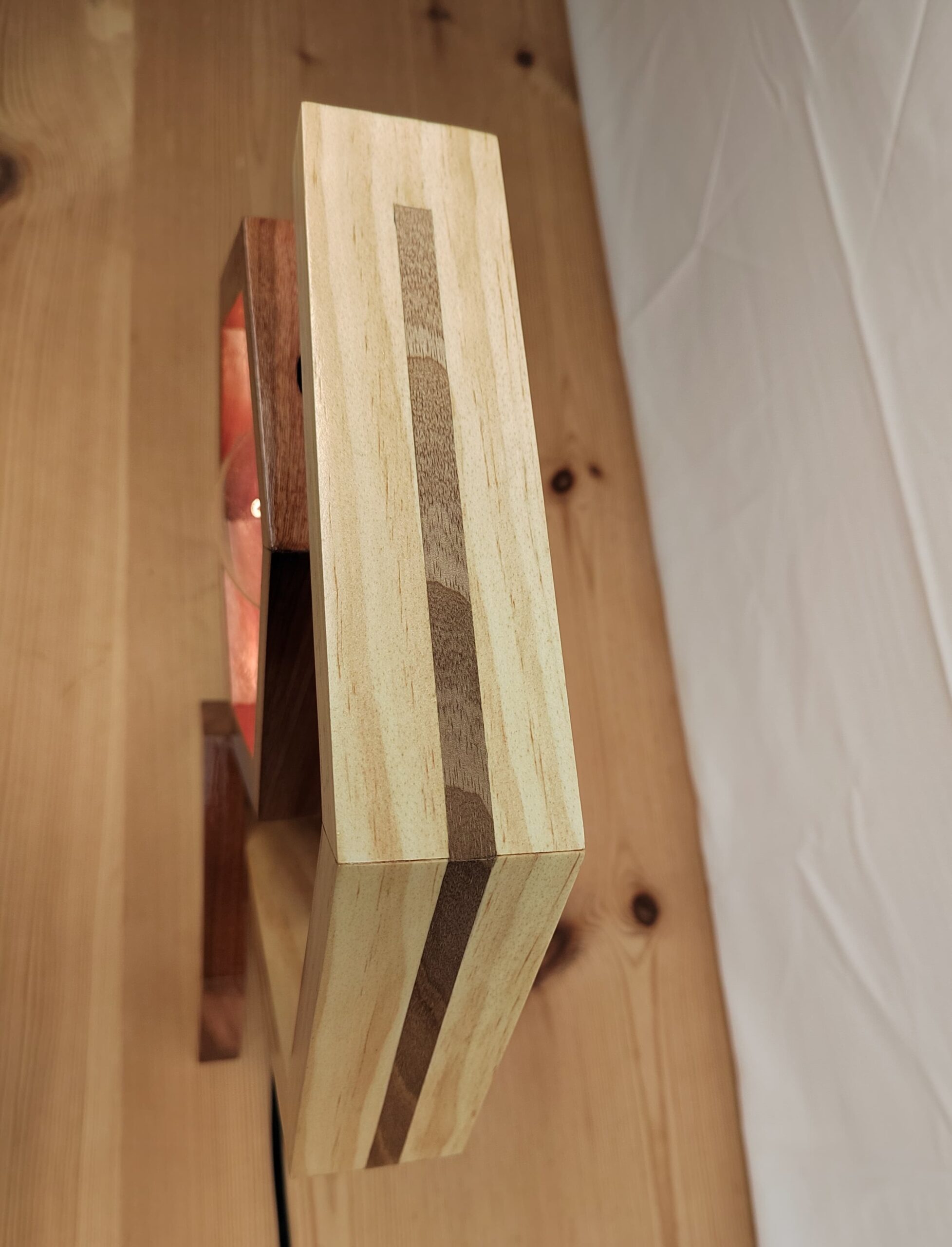 Lámpada artesanal de madeira con estrutura hexagonal, brazo bicolor e bombilla vintage Edison suspendida no centro