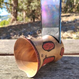 Amplificador de son pasivo artesanal feito en madeira torneada, con deseño tribal pirogravado e acabado en vermello e negro.