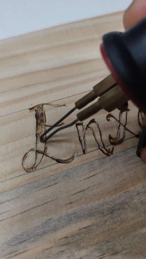 Detalle da punta do pirógrafo debuxando un trazo limpo