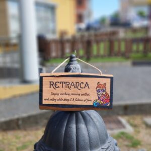 Cartel Retranca pirogravado en madeira de castiñeiro con ilustración de raposo, colgado nun farol