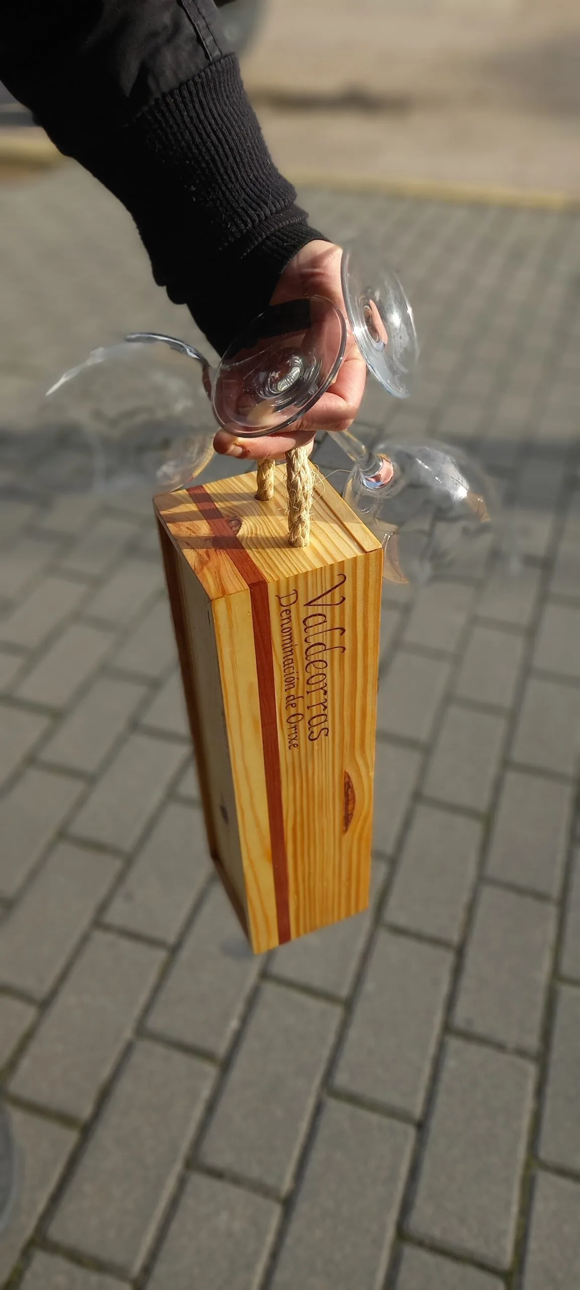 Caixa de madeira con asa para levar viño, sostida coa man