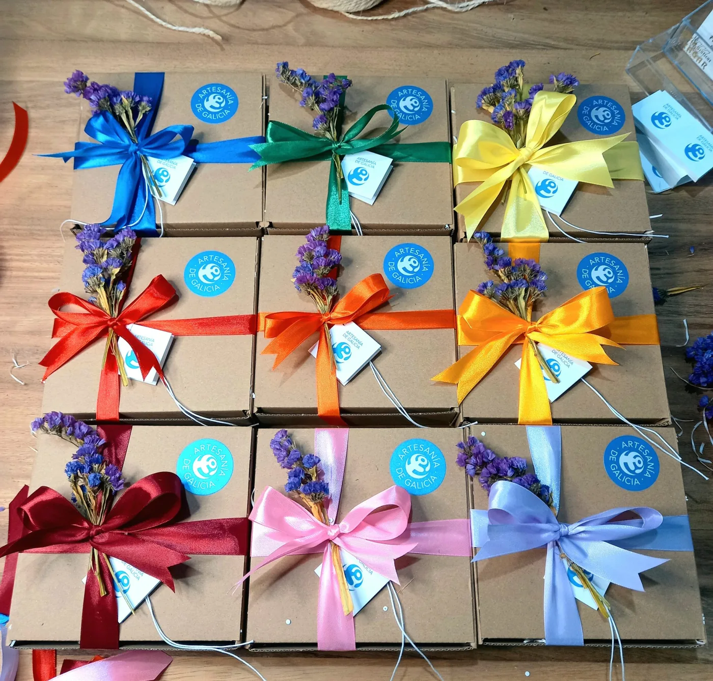 Caixas de agasallo de cartón con fitas de cores e flores secas, preparadas por Artesanía Enxebre