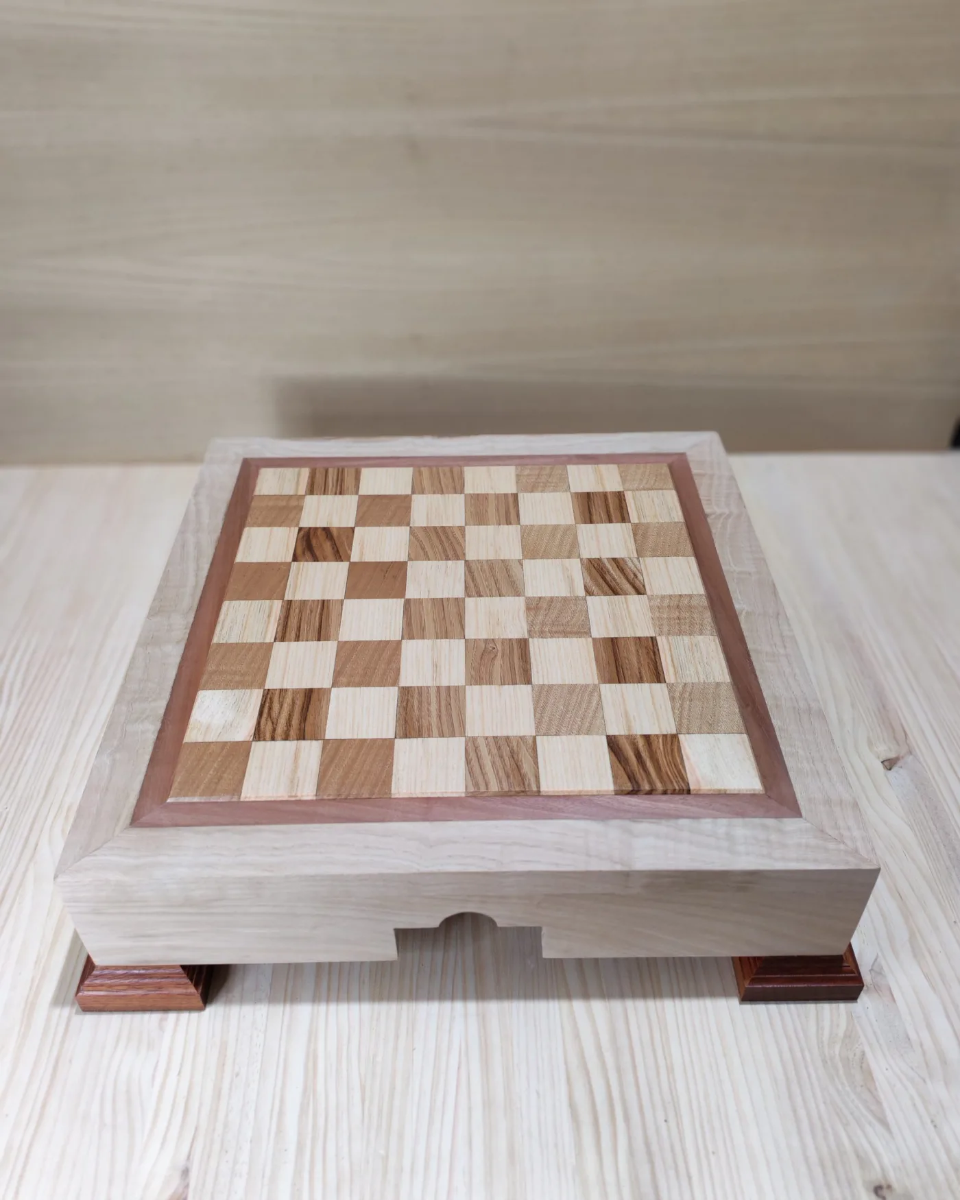 Tabuleiro de xadrez de madeira con casillas de marquetaría de varias madeiras e pes de madeira escura